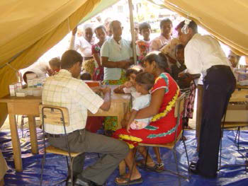 Families queueing to see doctor in a field tent