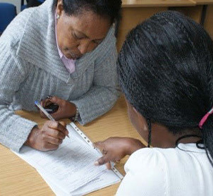 Woman helping refugee fill in a form